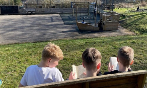 Bradwell students reading on a bench in the playground